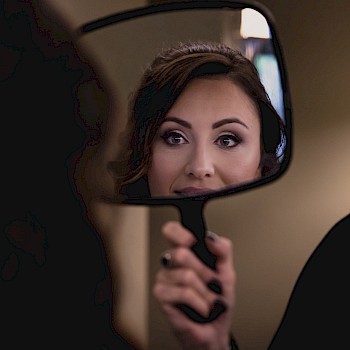 Alluring makeup looking in the mirror